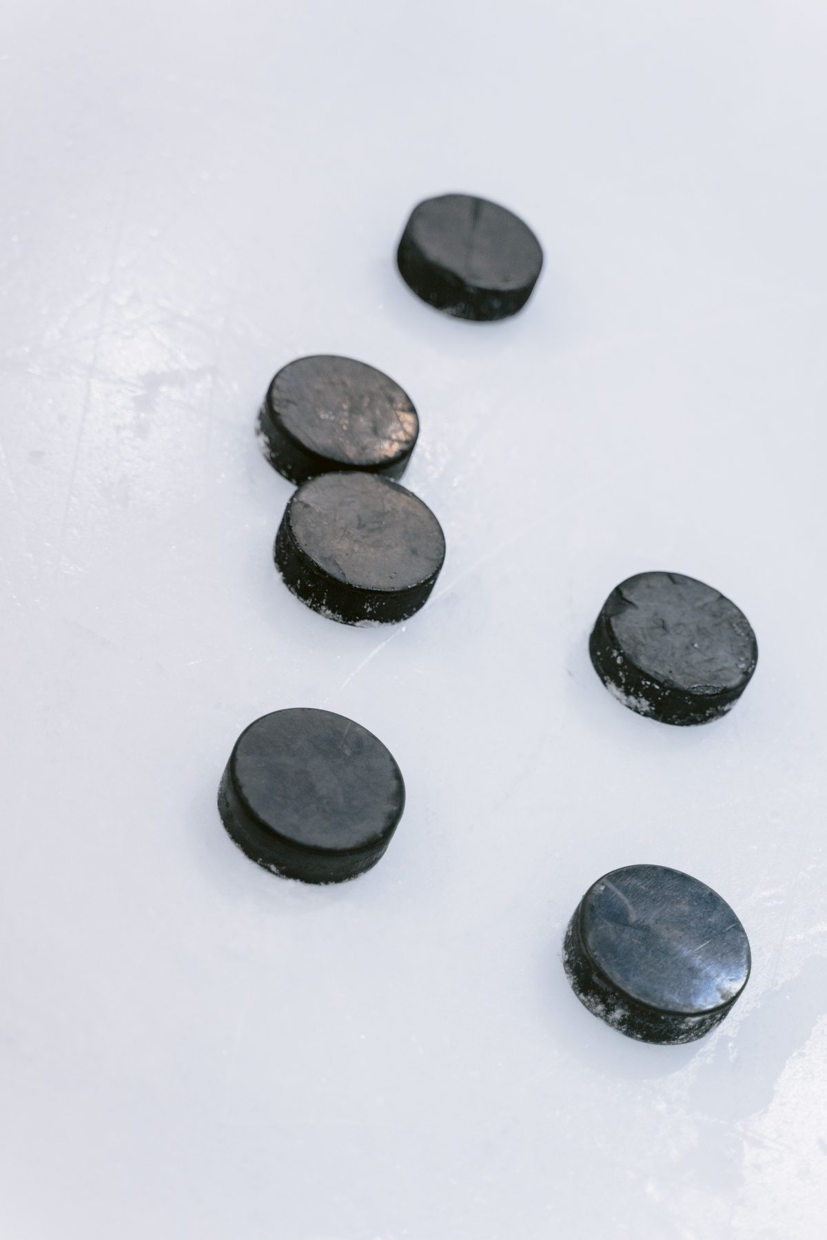 Practice pucks scattered on fresh ice